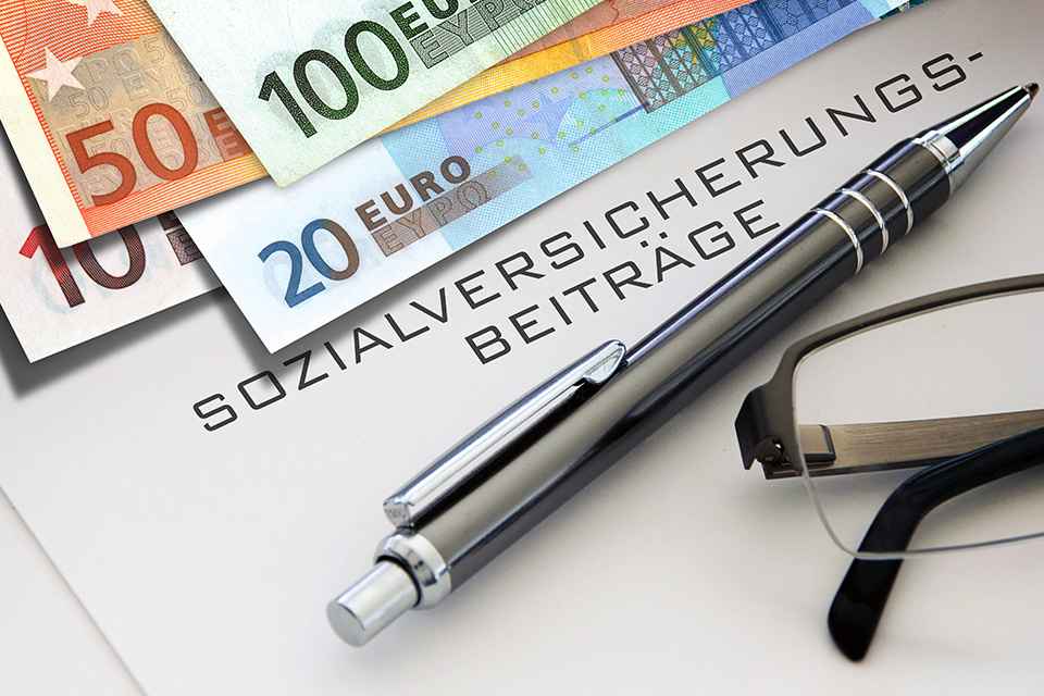 Foto: Euroscheinen und Schriftzug Sozialversicherung
